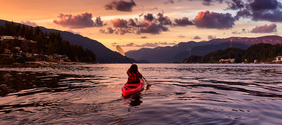 Adventurous paddling in kayak at sunset.