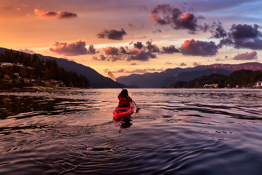 Adventurous paddling in kayak at sunset.