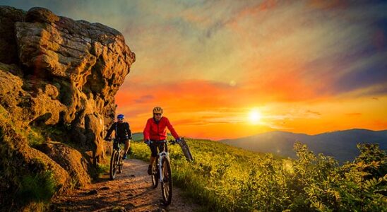 Mountainbiking man and woman, at sunset.