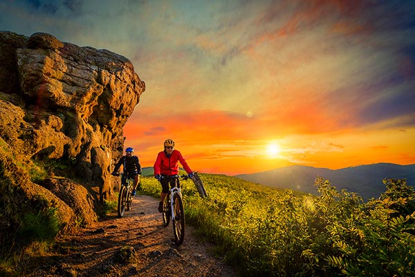 Mountainbiking man and woman, at sunset.