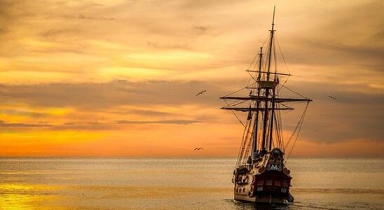 Sailing ship sailing into the sunset.