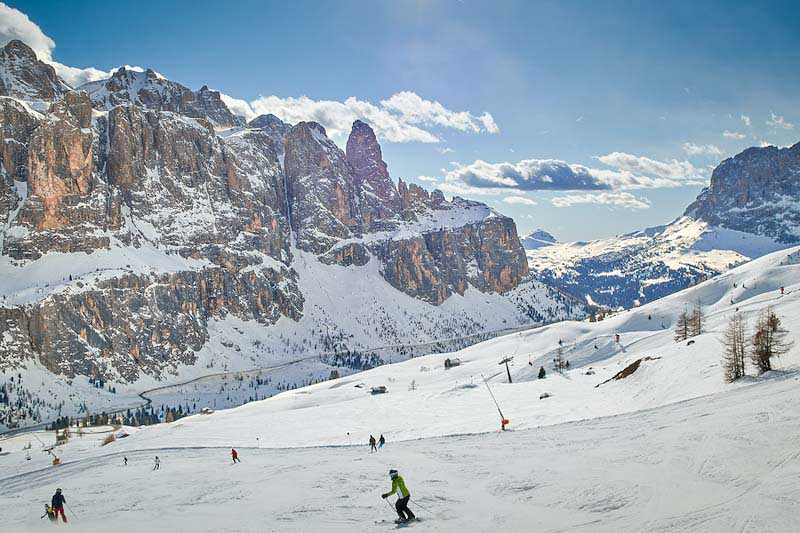 Skiers on a sunny day with mountains in the background