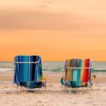 Orange sky and two beach chairs