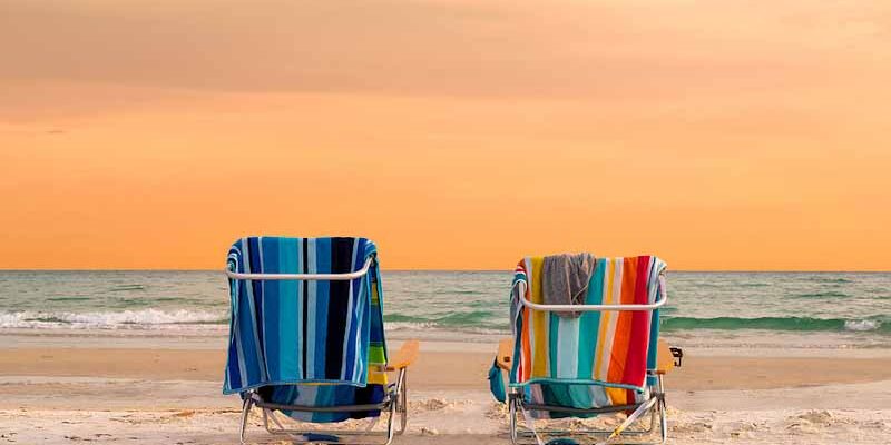 Orange sky and two beach chairs