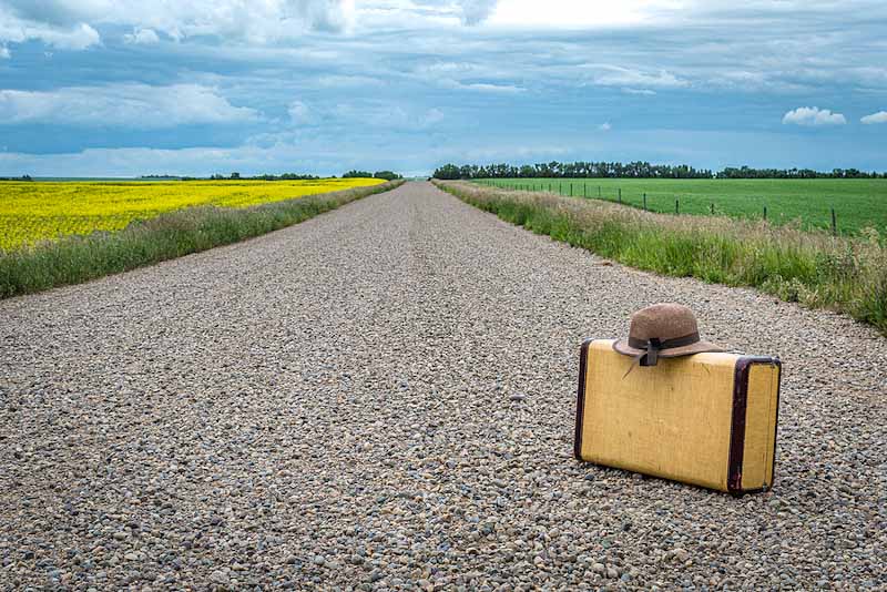 Vintage suitcase on a road.