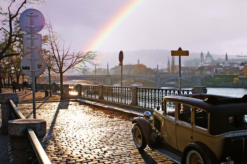 Classic car in Prague with rainbow in the background