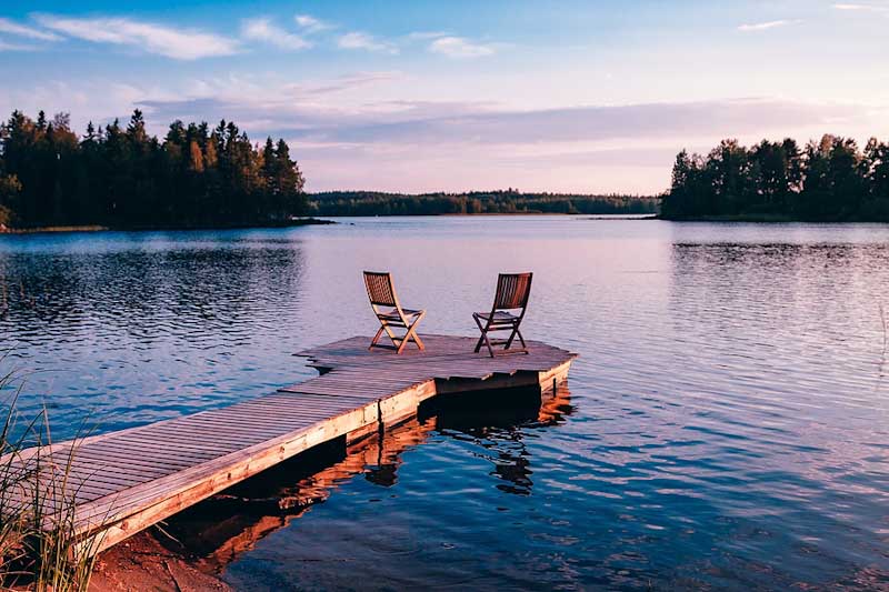 Wooden chairs on pier at sunset