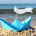 Blue paper boat on a beach