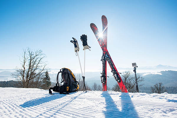 Skiis, gloves, and a backpack on a sunny day