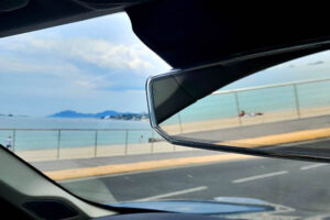 Rear view mirror showing beach in Cannes, France