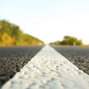 Asphalt road up close, with the horizon far away.