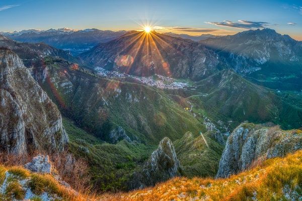 Sun setting behind mountains at dusk.